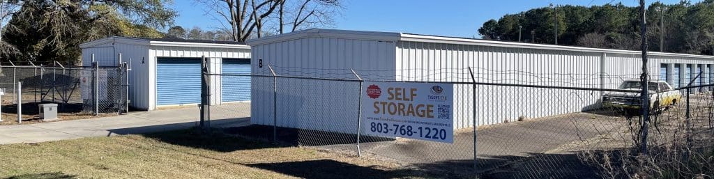 Tigers Eye Self Storage Bishopville Sign on fence exterior units Blue roll up doors